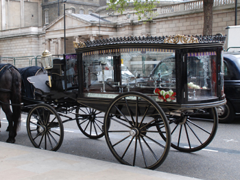 picture showing the splendid victorian glass sided hearse complete with black plumed horses and undertakers in big coats