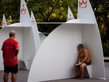 Photo of open-air confessional boxes in use